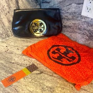 Black leather Tory Burch clutch.  2 zippered pockets.  Beautiful emblem.